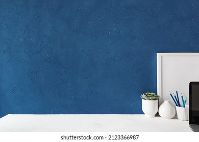 Home Office Desk With Blue Wall And White Table Mock Up.	
