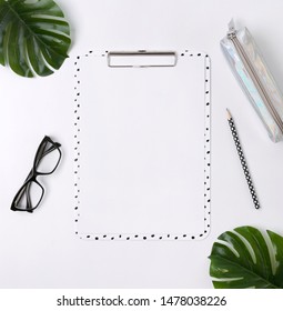 Home Office Desk With Clip Board, Glasses, Pencil Case, Green Leaves And Pensil. Workspace Mockup. Flat Lay, Top View