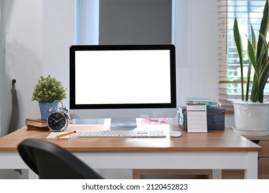 Home office desk with computer pc, houseplant, alarm clock and calendar. - Shutterstock ID 2120452823