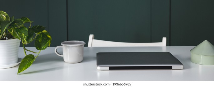 Home Office Desk, White Table With Laptop Closed, Mug And Plant.