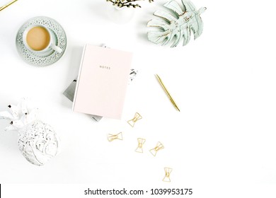 Home office desk. Workspace with pale pastel pink notebook, coffee and decorations on white background. Flat lay, top view.