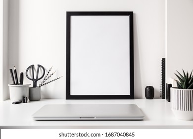 Home Office With Laptop Closed, Poster Frame Mockup And Black, Grey And White Elements. Trendy, Creative Desk.