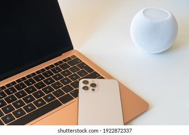 Home office. Laptop with empty screen, smart speaker and mobile phone on keyboard.