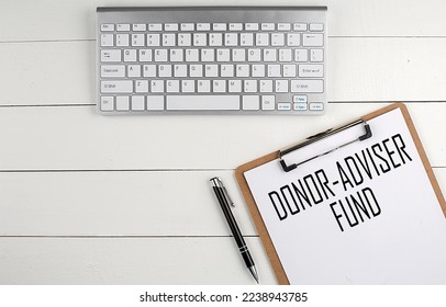 Home office workspace with keyboard, clipboard and pen with text DONOR ADVIDER FUND on white wooden background , business - Shutterstock ID 2238943785