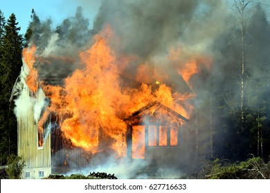 Home On Fire As The Flames Burst Through The Windows, Door And Roof Of The House