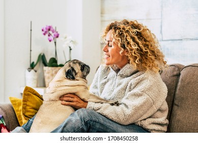 Home Pet Therapy Dog And Owner - Happy Caucasian Woman Have Fun Ith Their Lovely Pug On The Couch - Joyful With Domestic Animal - Couple Human Dog Best Friend Forever Concept