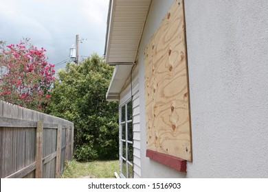 A Home With Plywood Covering The Window In Preparation For A Hurricane.  The Storm Clouds Are Gathering In The Sky.  Horizontal View.