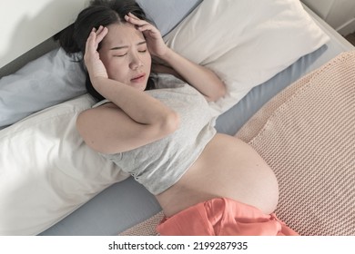 Home Portrait Of Young Tired And Depressed Asian Korean Woman Pregnant In Bed Having Nausea And Feeling Unwell Suffering Migraine And Pregnancy Body Pain