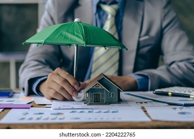 Home and real estate insurance ideas, individuals holding small umbrellas and sample homes. Home insurance for upcoming losses and fires building fire insurance