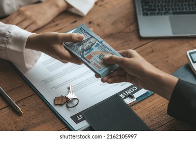 Home and Real Estate Selling Ideas, two people are real estate agents and a client is getting paid for the sale of the property after discussing the details and setting up a purchase agreement.