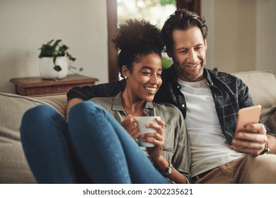 Home, relax and interracial couple on a couch, smartphone and happiness with connection, mobile app and social media. Partners, happy man and woman with a cellphone, communication and online reading - Powered by Shutterstock