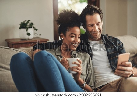 Home, relax and interracial couple on a couch, smartphone and happiness with connection, mobile app and social media. Partners, happy man and woman with a cellphone, communication and online reading