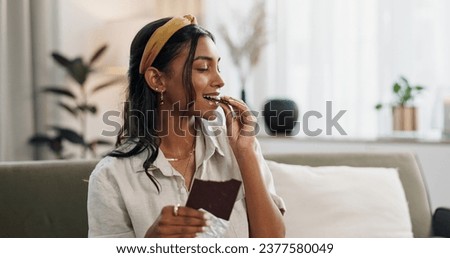 Home, relax and woman with chocolate bar, smile and eating with candy, hungry and dessert. Person, apartment or girl on a sofa, candy or sweet treats with a snack, nutrition or diet plan with cacao