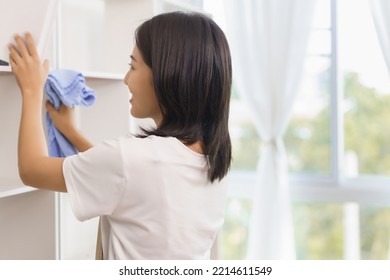 Home Relaxation Concept, Young Woman Use Fabric To Wipe Clean And Place The Books In Home Showcase.