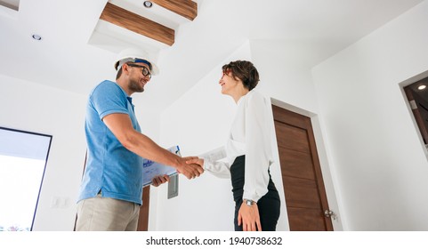 Home Renovation Concept - Builder With Blueprint Shaking Partner Hand