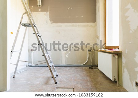 Home renovation concept. Kitchen in process of repair and renovation. Ladder and construction tools