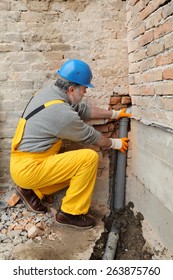 Home Renovation, Plumber Fixing Sewerage Pipe At Construction Site