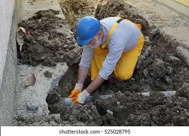 Home Renovation, Plumber Fixing Sewerage Pipe At Construction Site