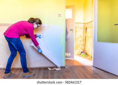 Home Renovation, Room Wall Repairing, Woman Removing Old Wallpaper