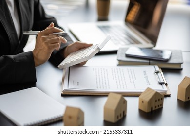 Home rental ideas, loans, mortgages and real estate valuations for sale. Businesswoman in a bank office is calculating a mortgage. - Shutterstock ID 2155337311