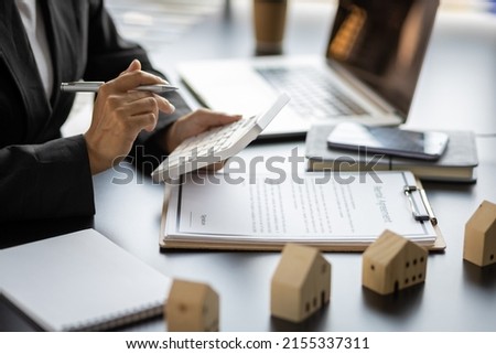 Home rental ideas, loans, mortgages and real estate valuations for sale. Businesswoman in a bank office is calculating a mortgage.