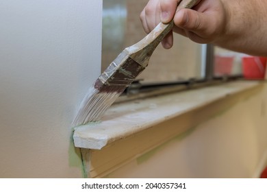 Home Restoration Worker Painting Using Paint Brush On Layer White Color A Window Frame Trim