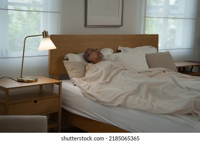 At Home Retirement Elderly Old Man Lonely Sick Laying Sleep On The Bed In Dark Bedroom 
