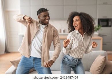 Home Romance And Fun. Positive Young African American Spouses Dancing Together Indoors, Making Funny Moves, Enjoying Domestic Party For Two, Spending Free Time In Modern Living Room - Powered by Shutterstock