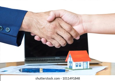 Home salesman shakes hands,Pen and model house on house plan,Model house with red roof and blue pen. - Powered by Shutterstock