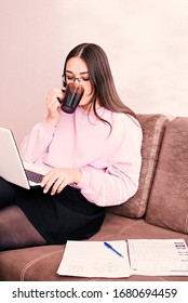 Home schooling. Student at home preparing to study sitting on the couch and studying the material on the laptop