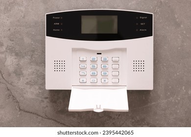 Home security alarm system on grey wall - Shutterstock ID 2395442065