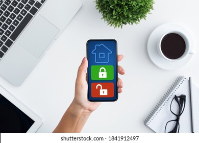 Home Security, Remote Control Concept. Above top view of woman using her mobile phone with application on the blue screen, monitoring her house at work. Burglary And Robbery Prevention