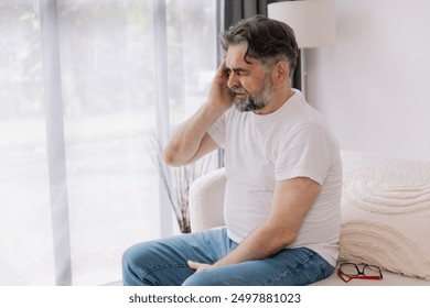 Home, senior man and headache on sofa for stress, emotional conflict and temporal vertigo. Living room, couch and old person with pain, migraine and anxiety due overthinking in retirement in house - Powered by Shutterstock