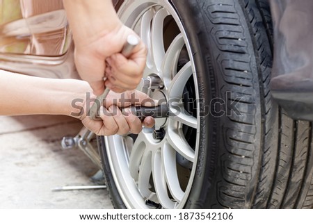 Home service car concept : A man repairing action lock bolt of car wheel for check the car's drive system basic maintenance that can be made by yourself