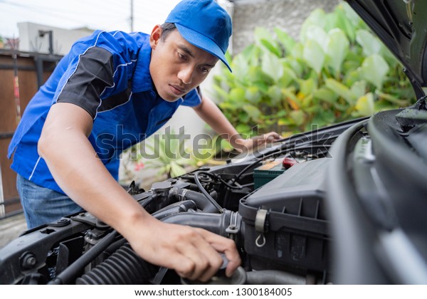 home service mechanic doing some inspection on\
car\'s engine