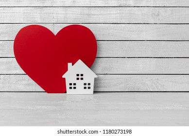 Home Shaped with Red Heart Shaped on white wood over white wood background