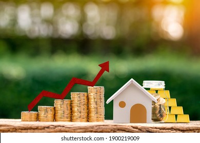 Home And Stack Coin And Clear Bottle Bank And Gold Bar And Red Arrow And Graph With Growing Value In The Public Park, Business Investment For Fund Of Real Estate Concept.