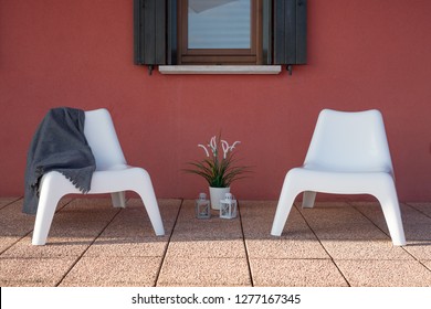 HOME STAGING - Small Outdoor Veranda Garden With Two Designer Chairs And Red Wall