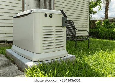 A Home Standby Generator installed at the backyard of a house. An air-cooled natural gas or liquid propane generator for residential use.
