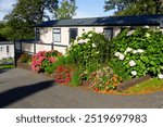 Home from home, static caravan, mobile home, parked on Caravan Park with a lovely flower garden surrounding it.