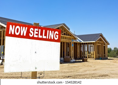 Home Is Still Under Construction With A Sell Sign In The Foreground. 