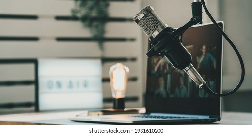 Home studio podcast interior. Microphone, laptop and on air lamp on the table - Shutterstock ID 1931610200