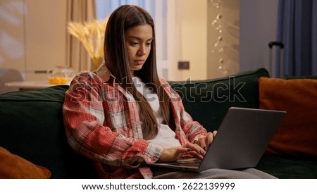 Home studying e-learning using laptop Caucasian teen girl student businesswoman freelancer on couch female woman teenager concentrated working computer online shopping at night home typing pc addict