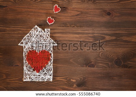 Home sweet home. Handmade home symbol with heart shape on wooden background with copy space