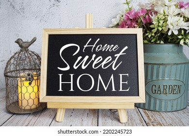 Home Sweet Home Text Message Written On Blackboard Standing On Wooden Background