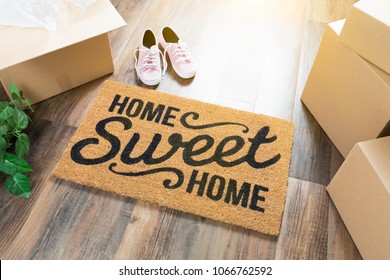Home Sweet Home Welcome Mat, Moving Boxes, Pink Shoes and Plant on Hard Wood Floors.