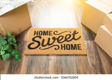 Home Sweet Home Welcome Mat, Moving Boxes and Plant on Hard Wood Floors.