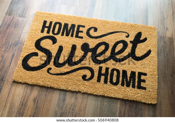 Home Sweet Home\
Welcome Mat On Wood Floor.