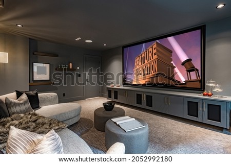 home theatre with low lighting grey furnishings large projection screen and popcorn
