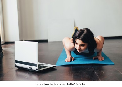 Home Training,sport, Online Fitness Class. Young Fit Woman Doing Exercise On Mat Looking Video Guide On Laptop